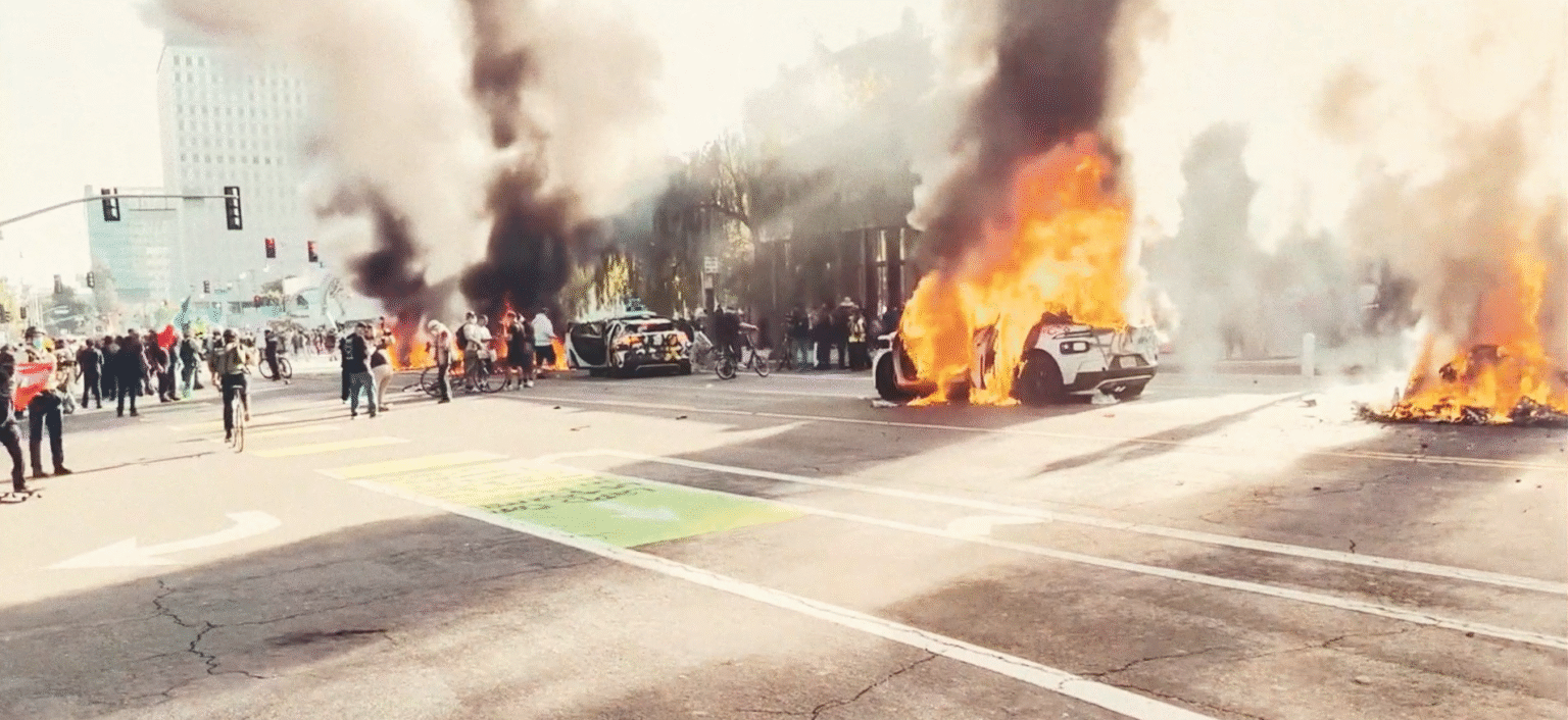 LA riots: Police vehicles on fire during ICE protest.