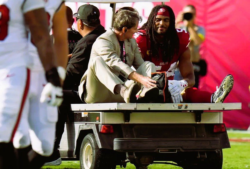 Fred Warner walking off the field with a cart after suffering a broken and dislocated ankle during a 49ers game.