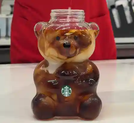 Starbucks 2025 Bearista cup with beanie and straw on a wooden table