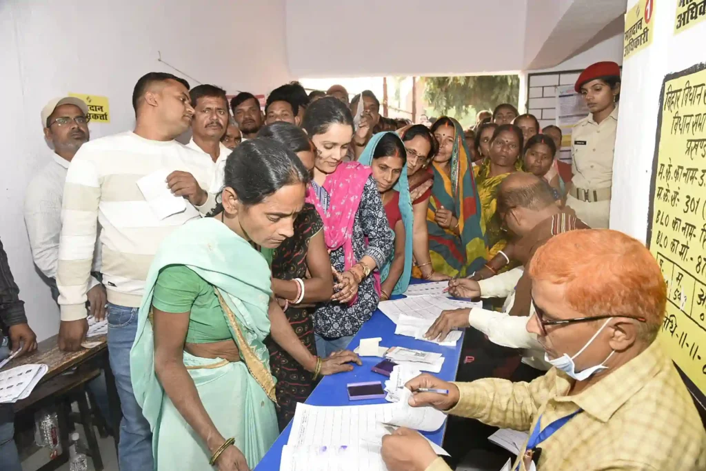 Voters standing in line and completing verification at a polling booth during the Bihar Election 2025, showing strong turnout that contributed to the NDA win in Bihar.