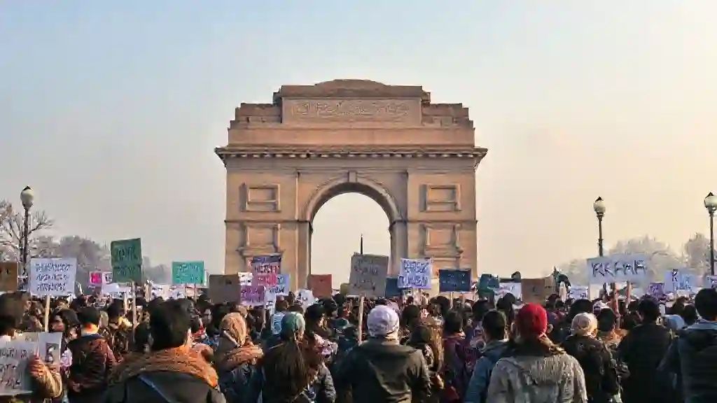 Citizens rally at India Gate in Delhi against toxic winter smog, holding banners demanding clean air.