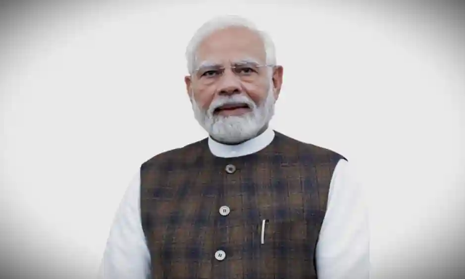 Prime Minister Narendra Modi at a public event, smiling.