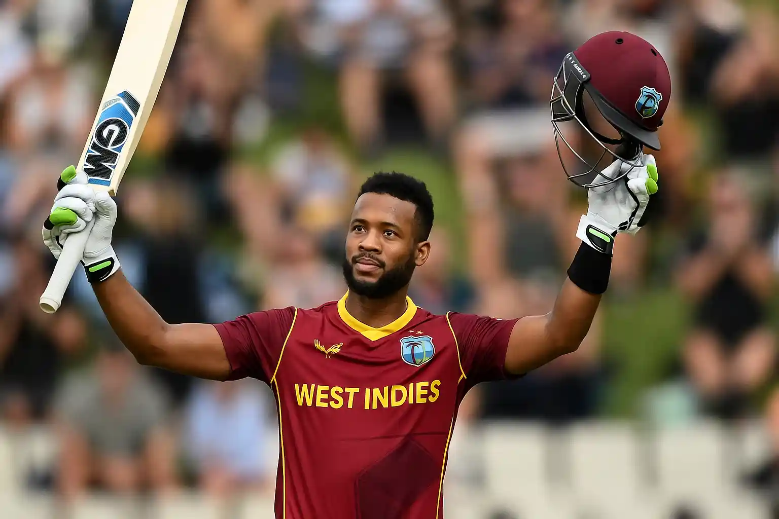Shai Hope celebrates his century by raising his bat and helmet during an ODI match, highlighting the brilliance of Shai Hope centuries.