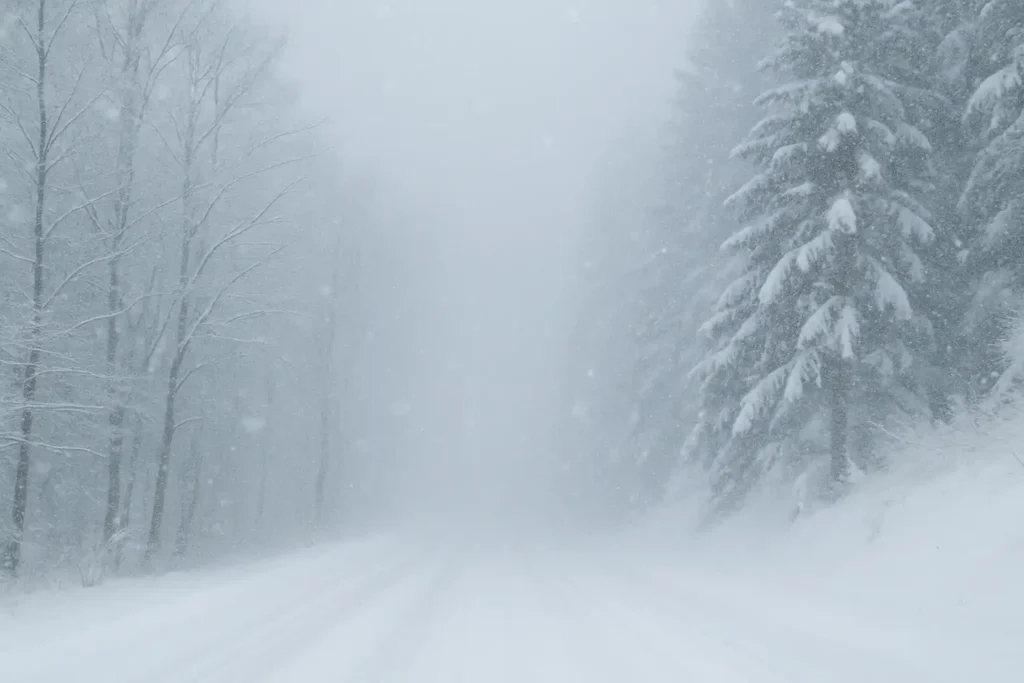 Snow-covered road during a Lake-effect snow warning in Western Pennsylvania with heavy snowfall reducing visibility.