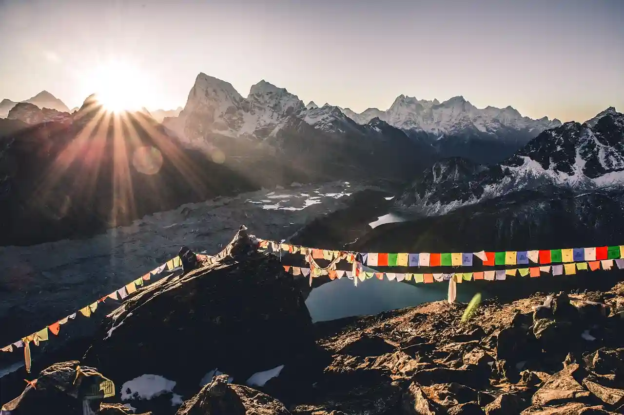 Himalayan mountain sunrise with prayer flags in Nepal, representing the region highlighted in the Nepal earthquake update