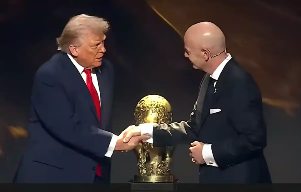 Donald Trump shaking hands with FIFA President at event, linked to FIFA Peace Prize announcement.