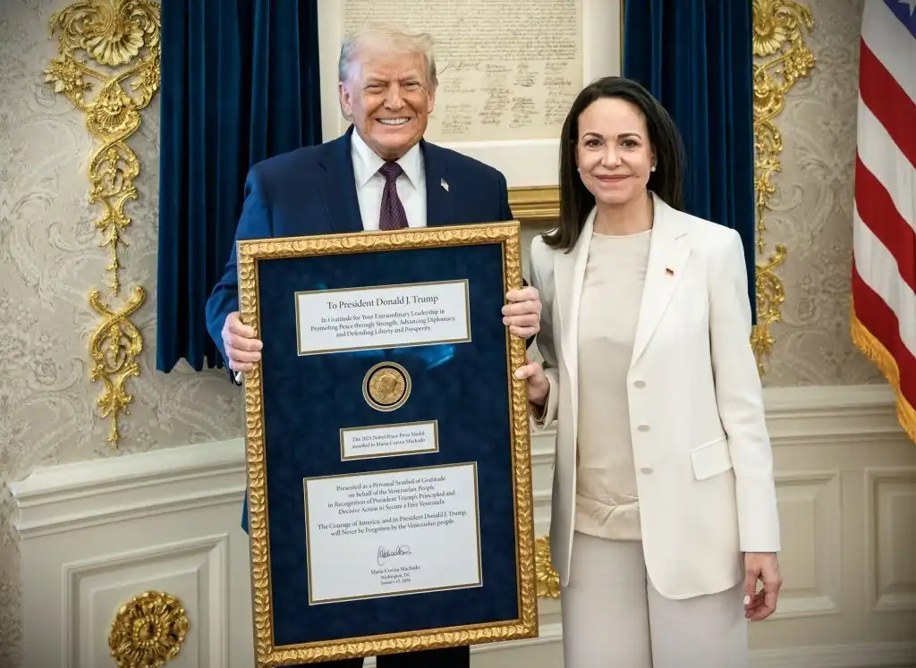 Donald Trump holds a framed Nobel Peace Prize medal presented by Maria Corina Machado during a White House meeting