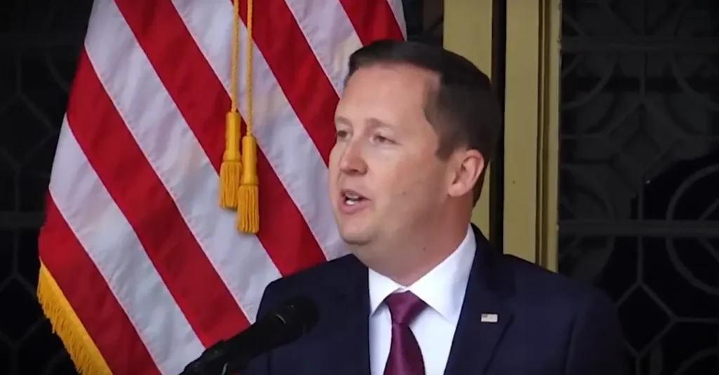 Sergio Gor speaking at a podium with the US flag behind him during his Sergio India speech on US-India relations